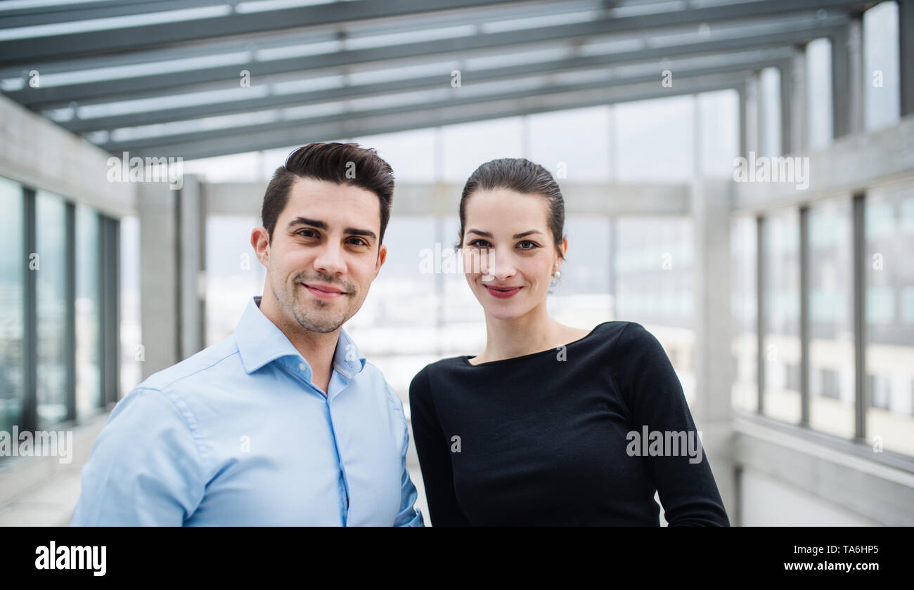 Two young architects standing in office, looking at camera. Stock Photo