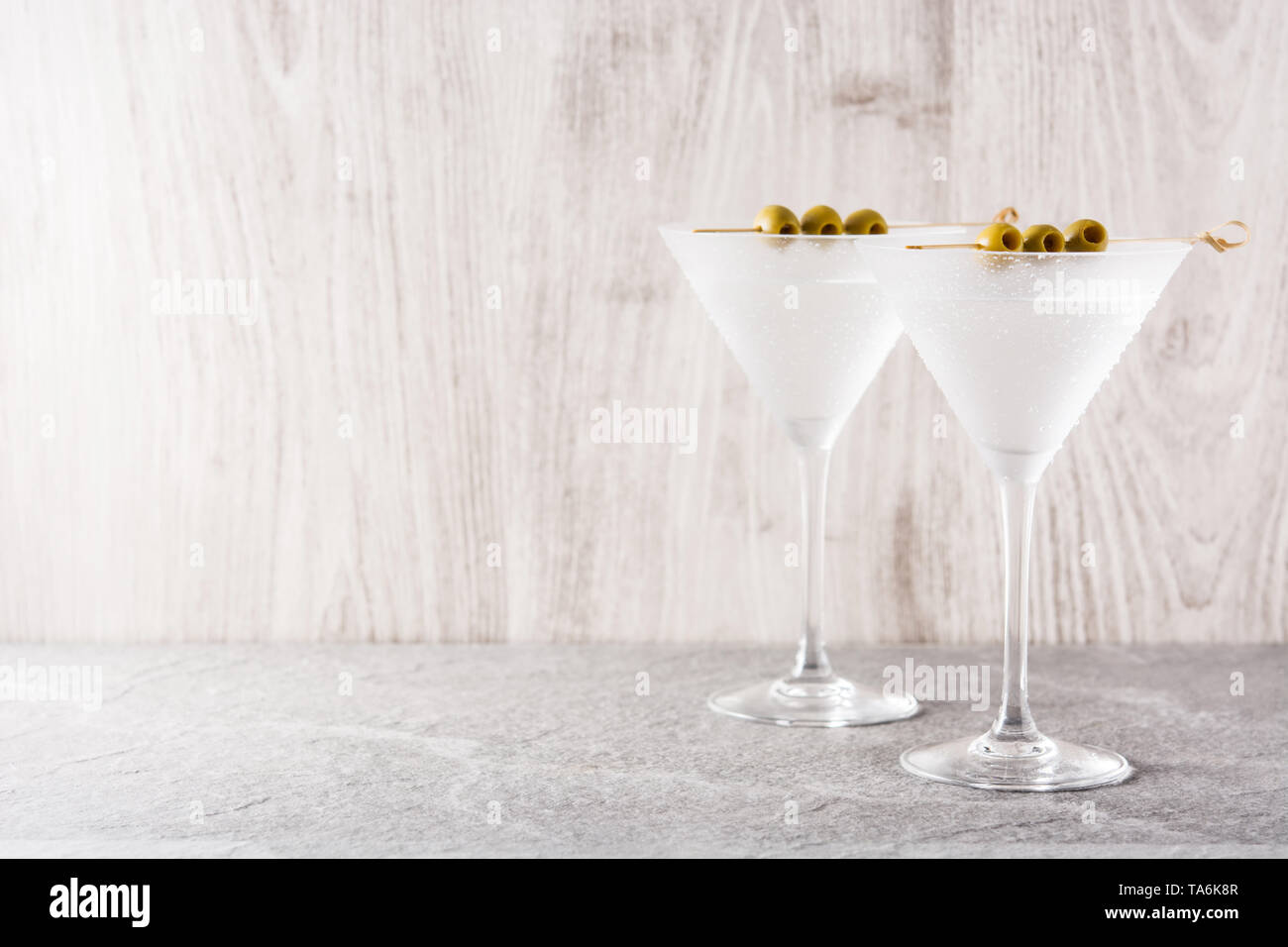 Classic Dry Martini with olives on gray background. Copyspace Stock Photo