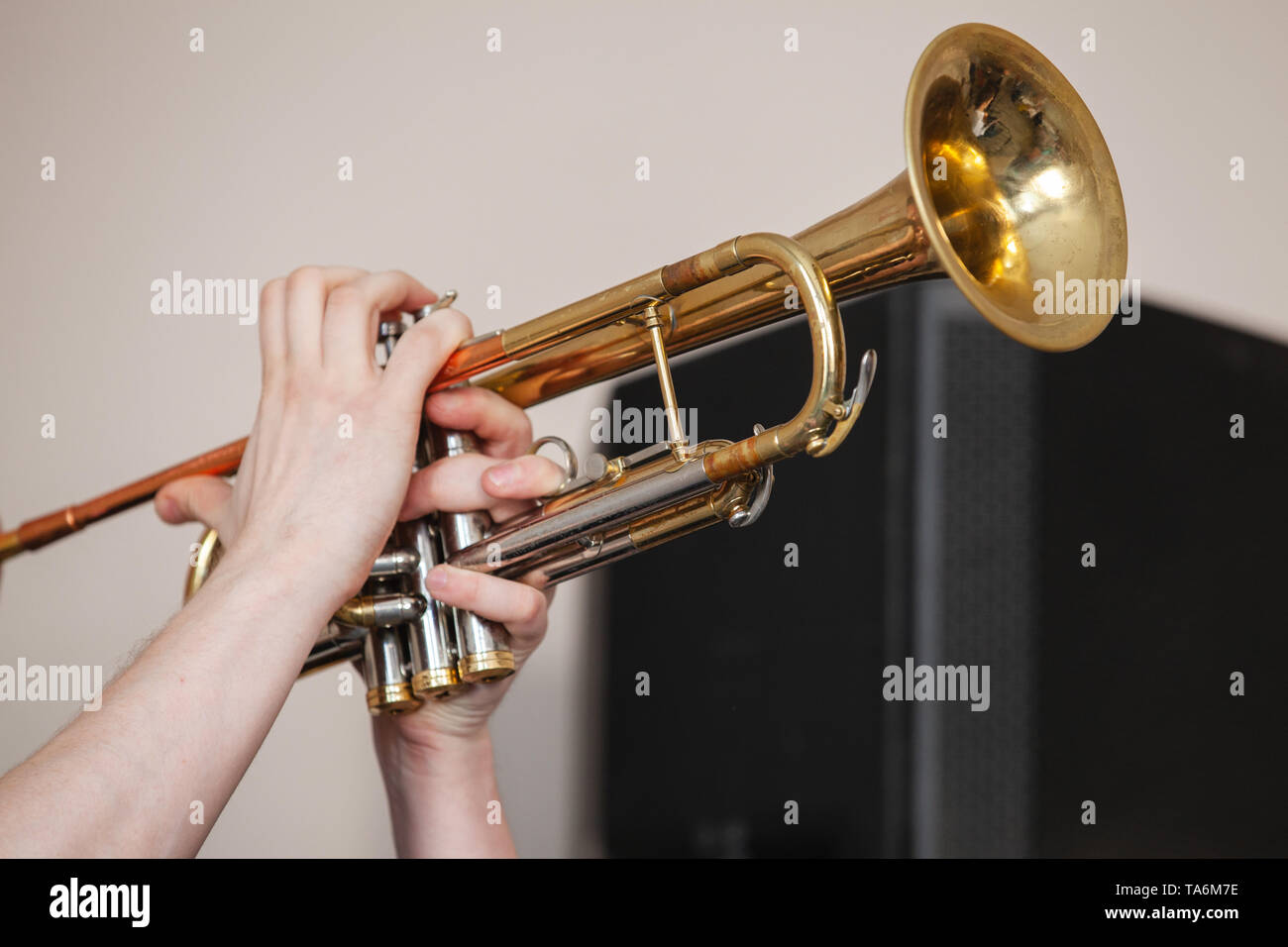 Trumpet in trumpeter hands. It is a brass instrument commonly used in classical and jazz ensembles Stock Photo