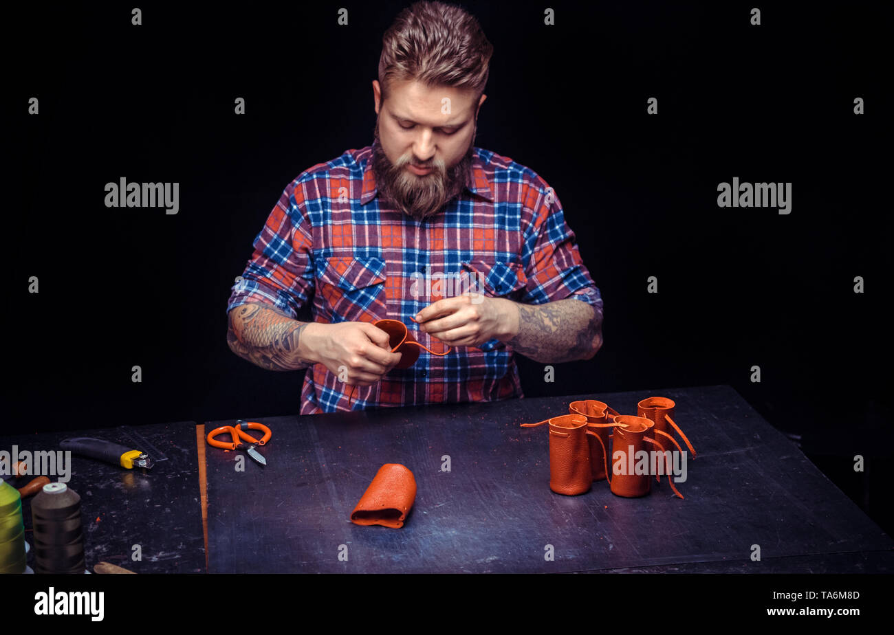 Leather Currier producing a leatherwork at his workshop Stock Photo