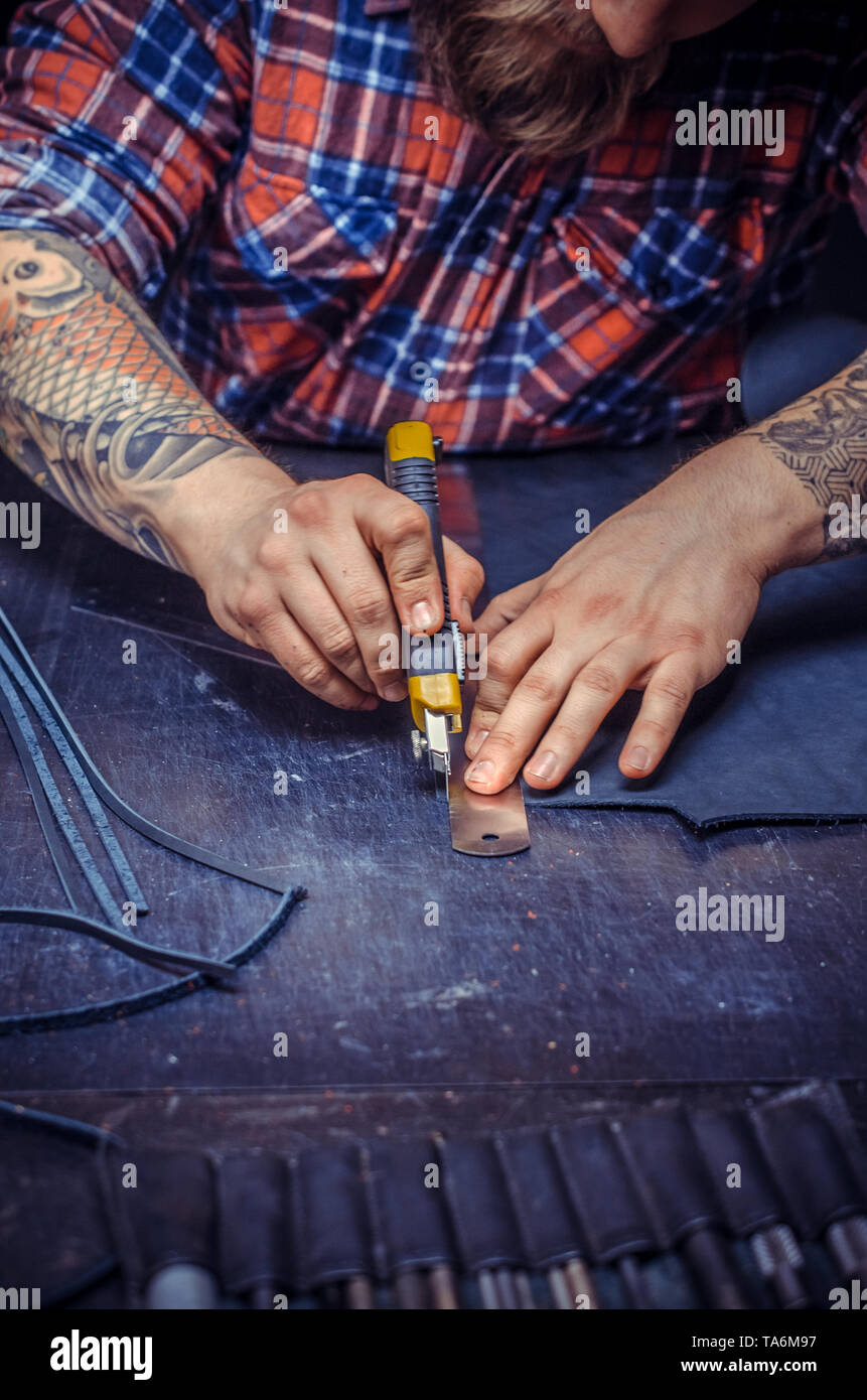 Artisan cutting out leather goods  Stock Photo