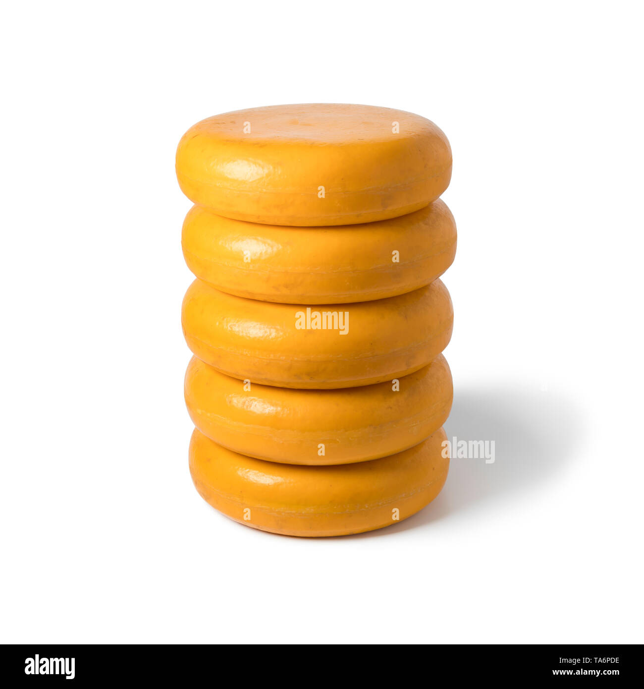 Stack of round whole yellow cheeses isolated on white background Stock Photo