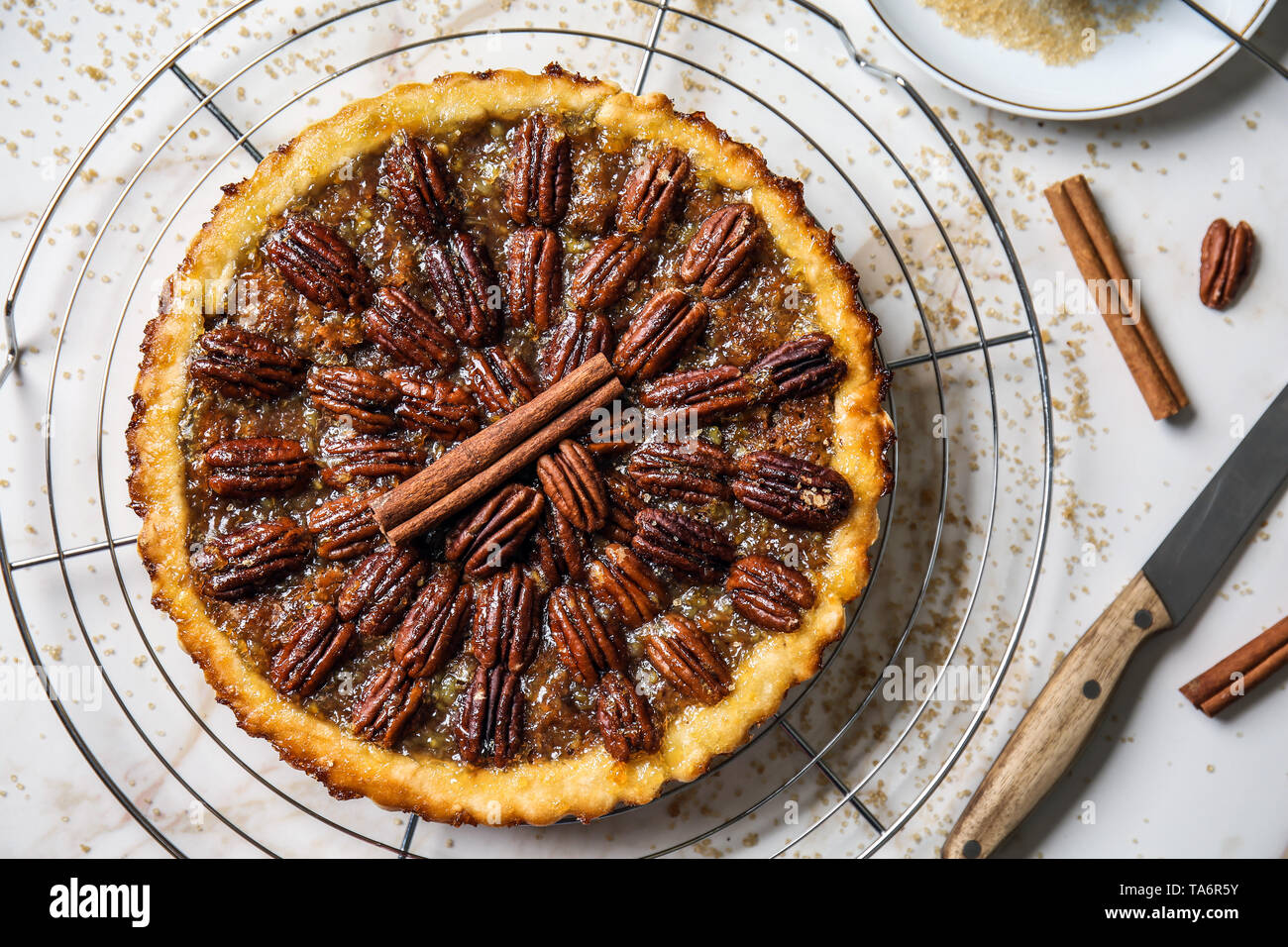 Cooling rack with tasty pecan pie on light table Stock Photo