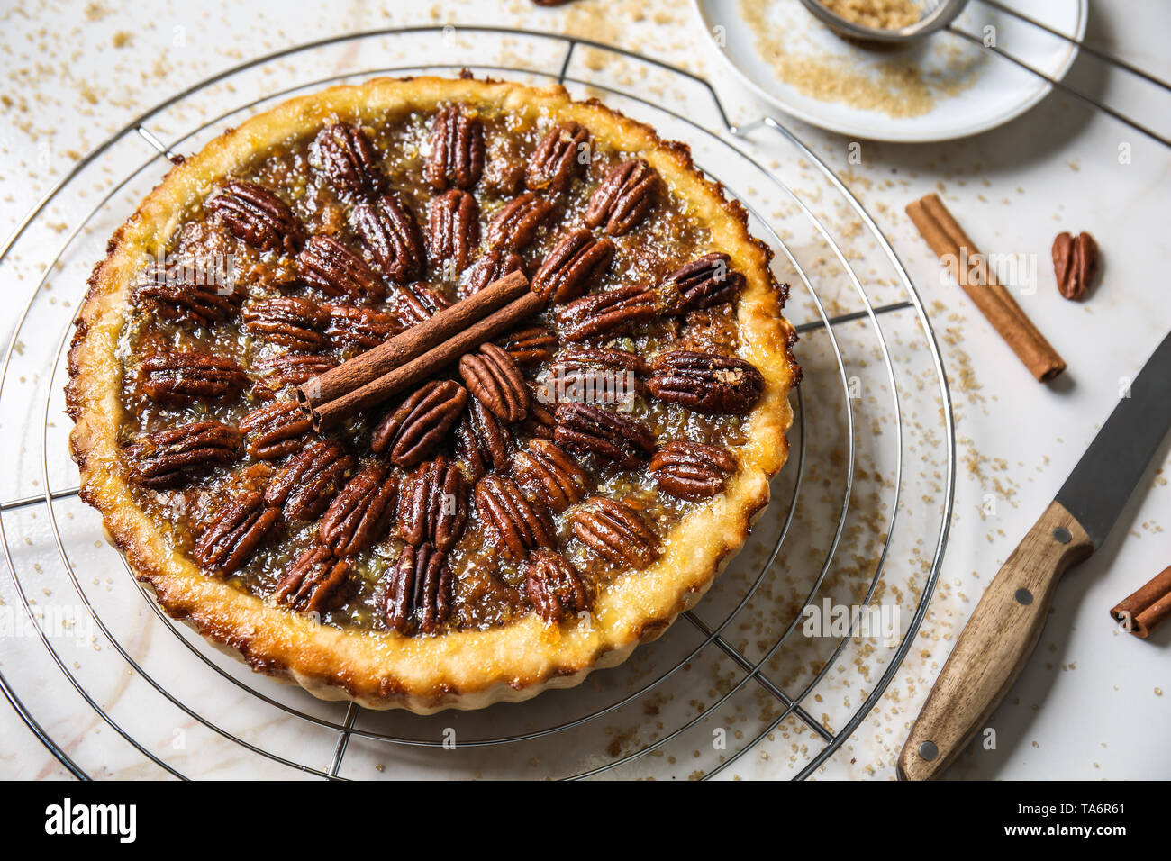 Cooling rack with tasty pecan pie on light table Stock Photo