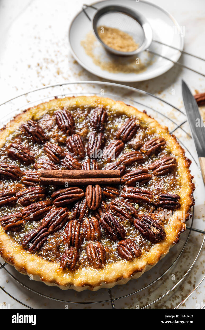 Cooling rack with tasty pecan pie on light table Stock Photo