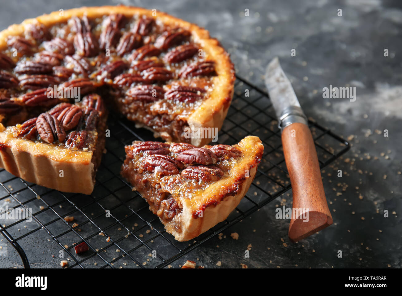 Cooling rack with tasty pecan pie on grey background Stock Photo