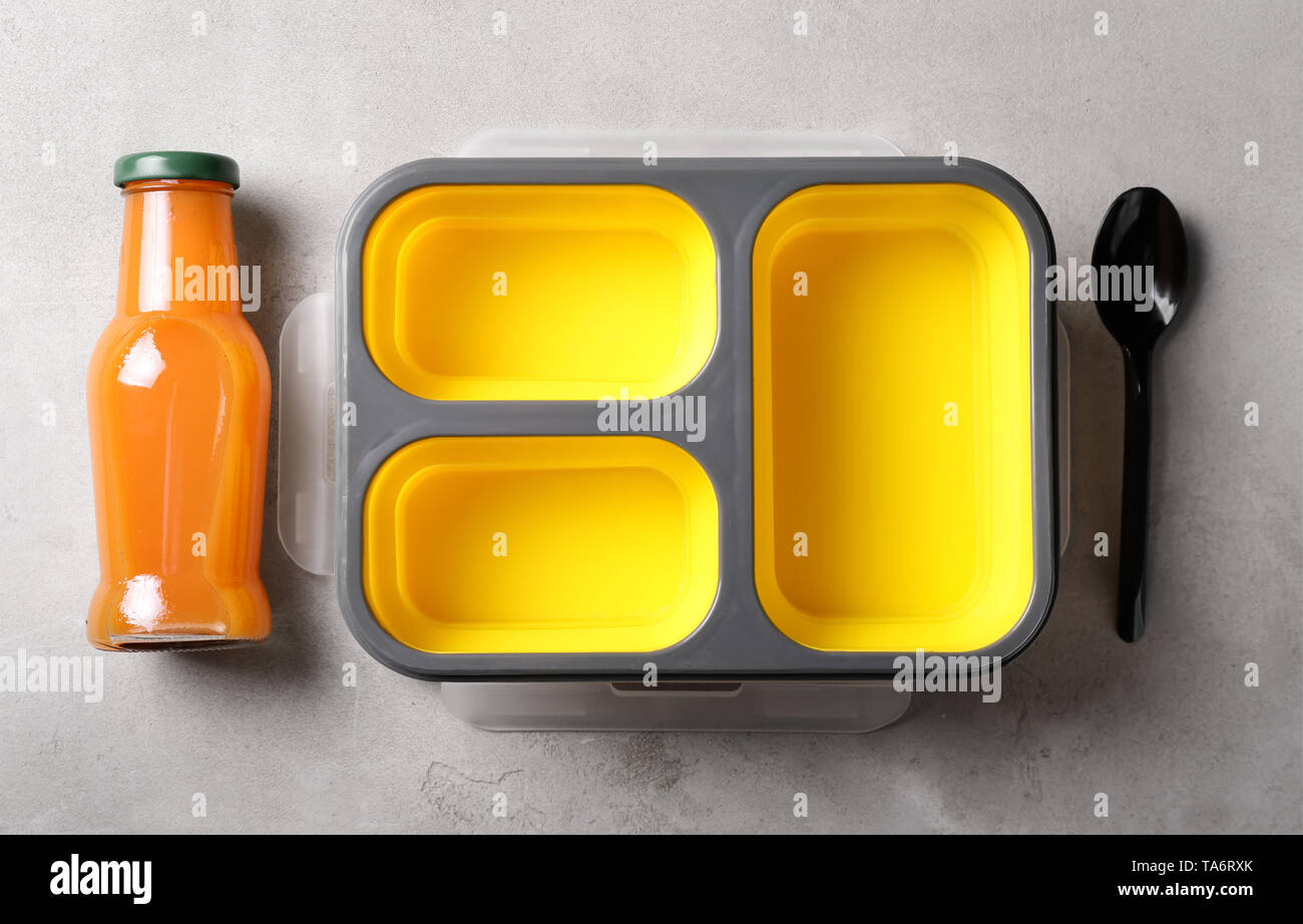 Empty school lunch box and bottle of juice on grey background Stock