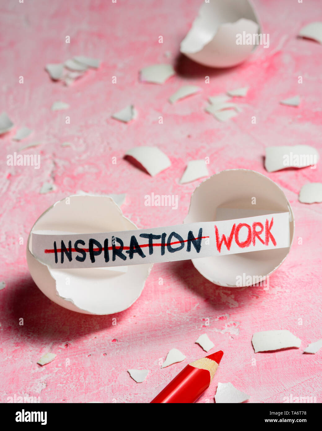 Work hard and inspiration concept. Cracked egg on pink background with text INSPIRATION and WORK. Like fortune cookies Stock Photo