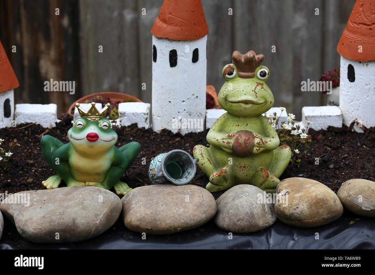 Ornamental frogs stand near a garden pond Stock Photo Alamy