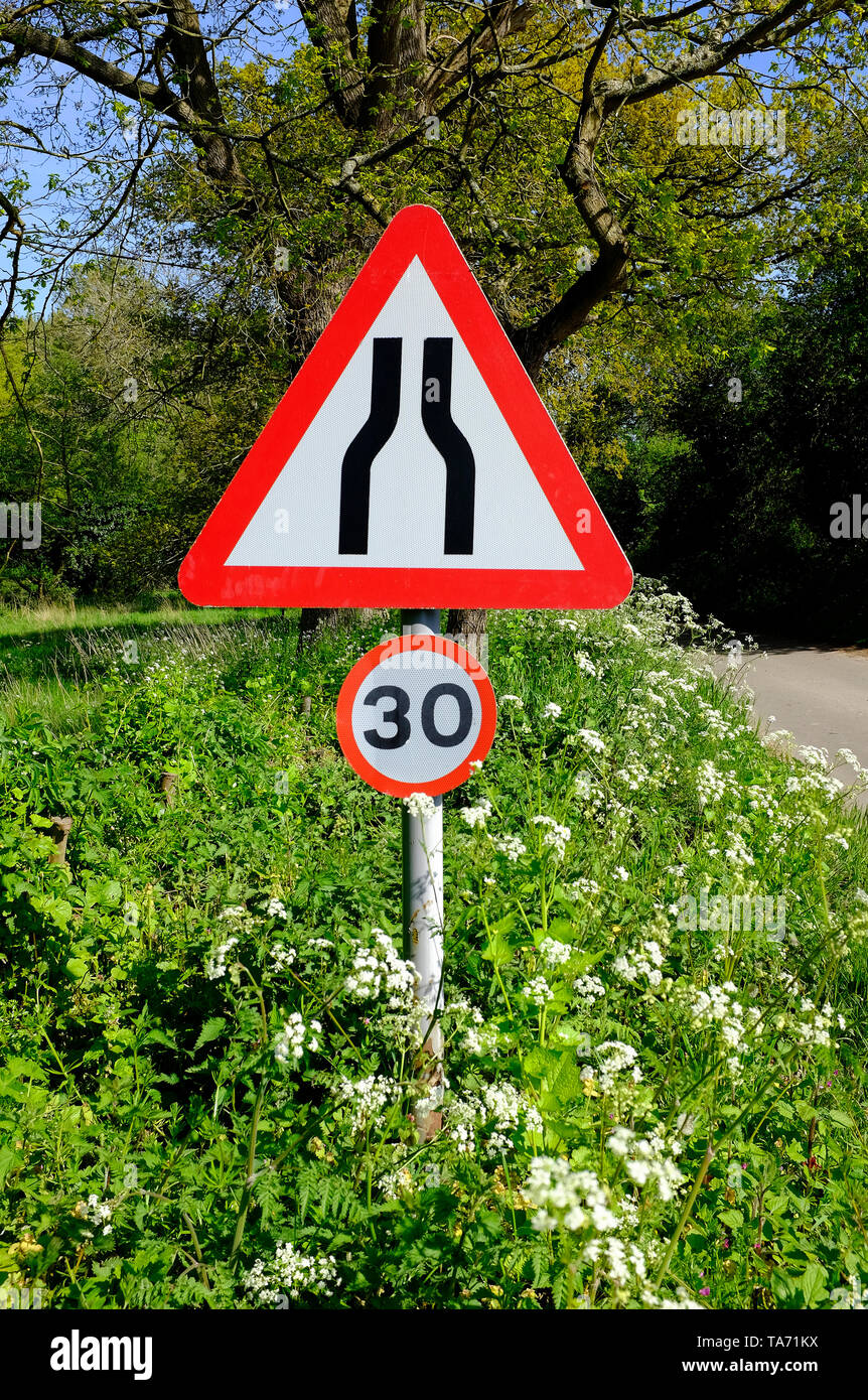 road narrows road sign and 30mph speed limit signs, north norfolk, england Stock Photo