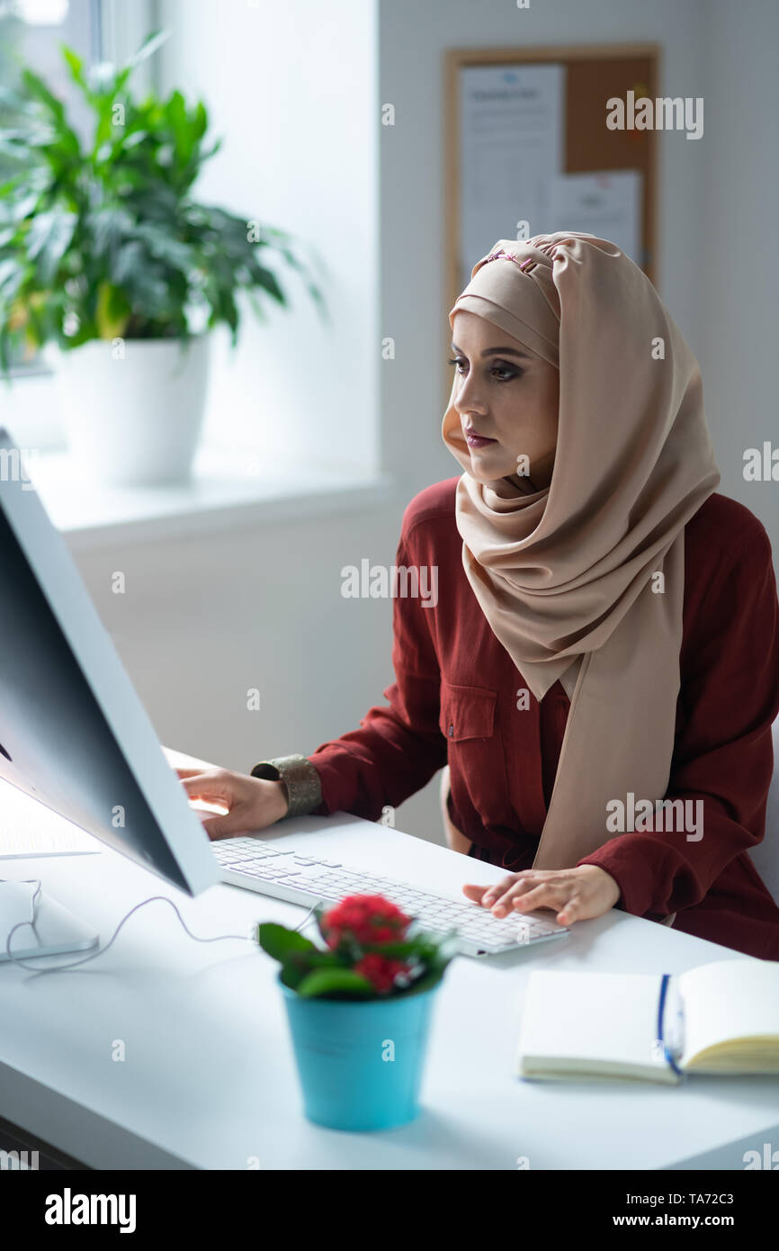 Woman feeling busy while working sitting near computer Stock Photo