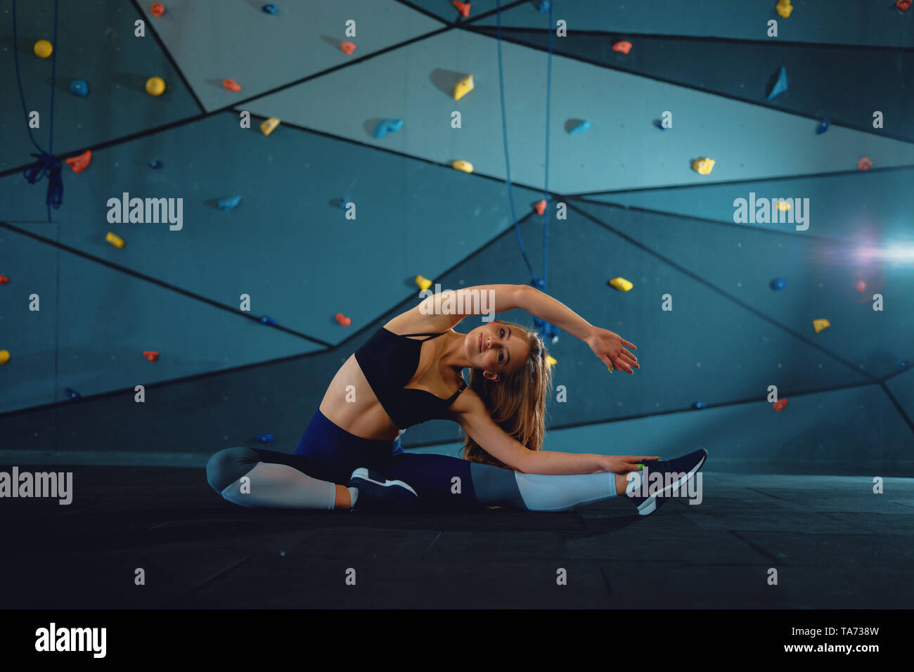 Stretching gymnast girl doing vertical split, twine. Front view of