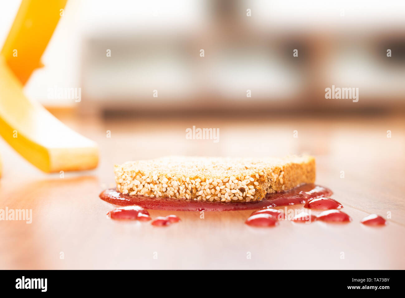 Concept representation of Murphy’s law with a slice of bread fallen upside down Stock Photo
