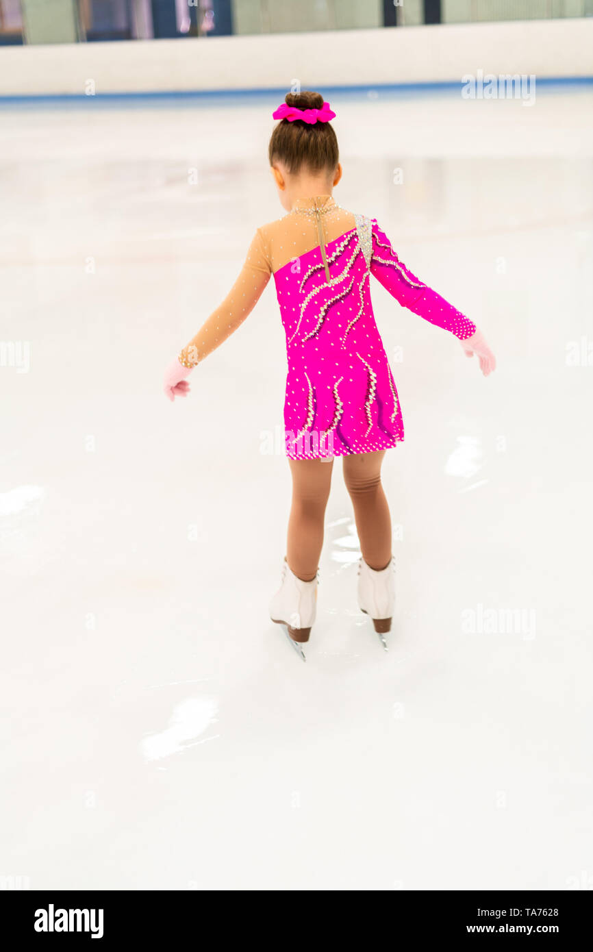 Little figure skater in pink dress practicing on the indoor ice rink Stock Photo Alamy