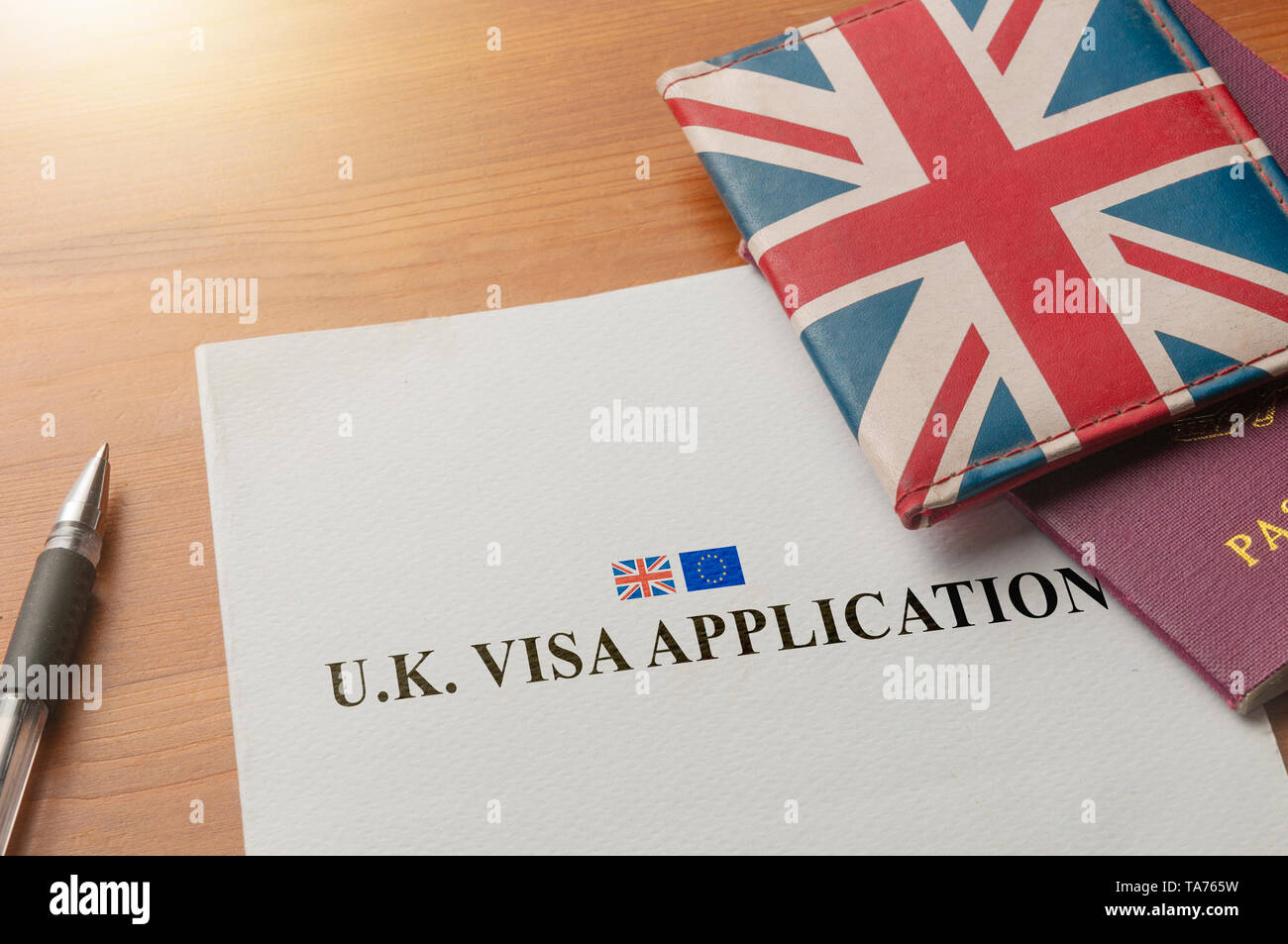 Visa application on desktop with passport and union jack wallet Stock Photo