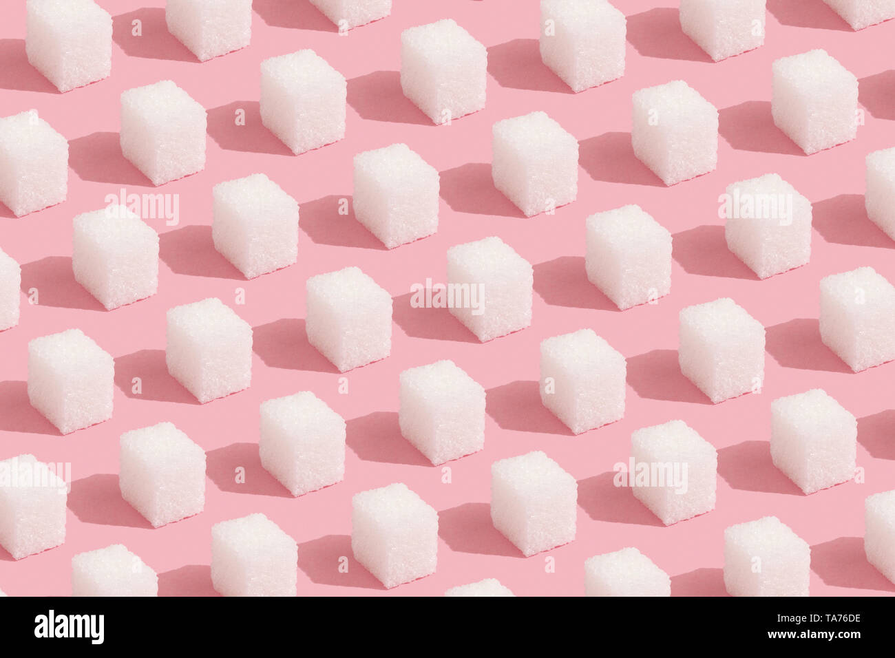 Geometry Pattern made of white sugar cubes on pastel pink trendy background. Abstract, minimal style. Stock Photo