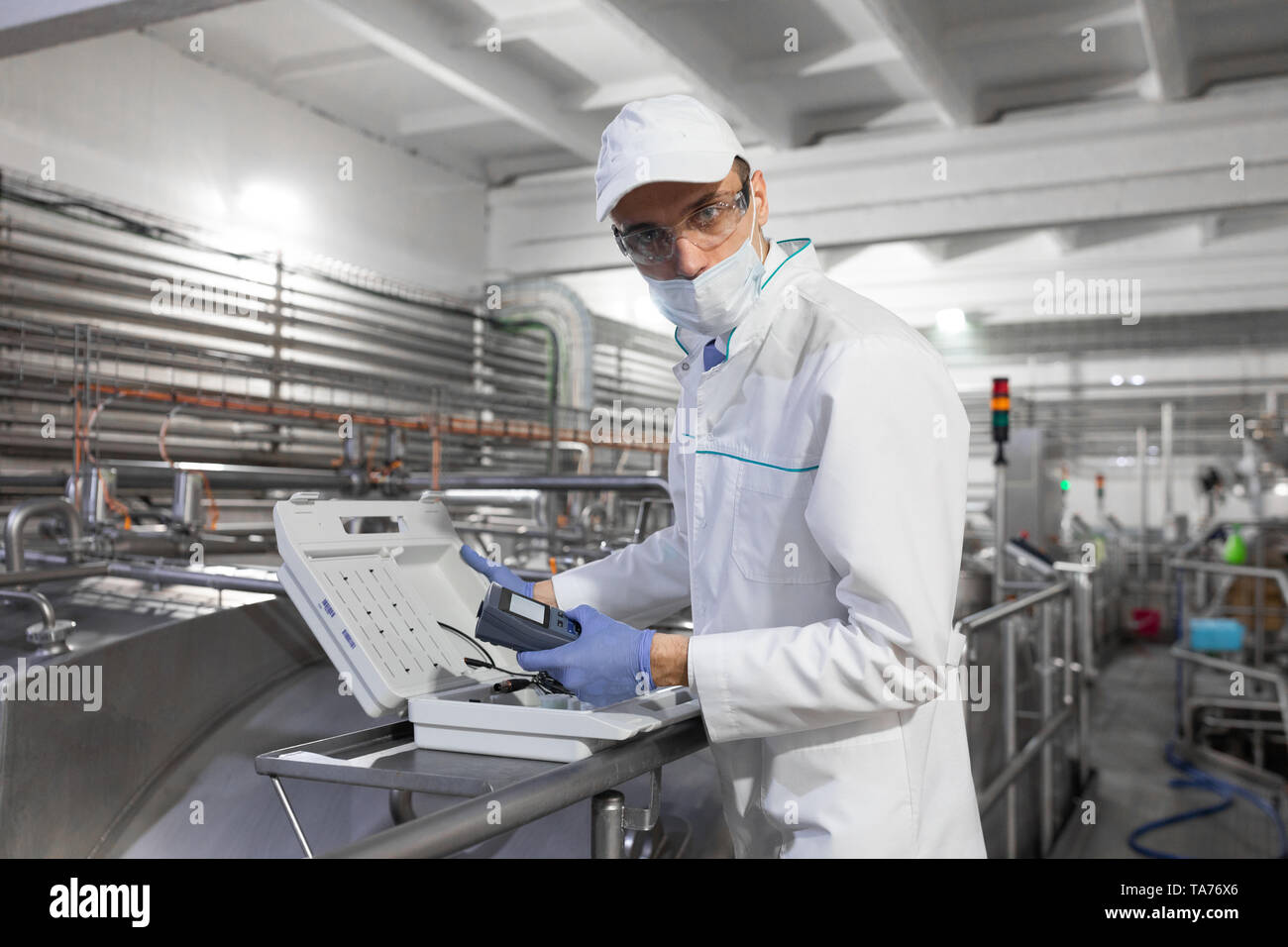 man in a white robe and a cap make a configure of device Stock Photo