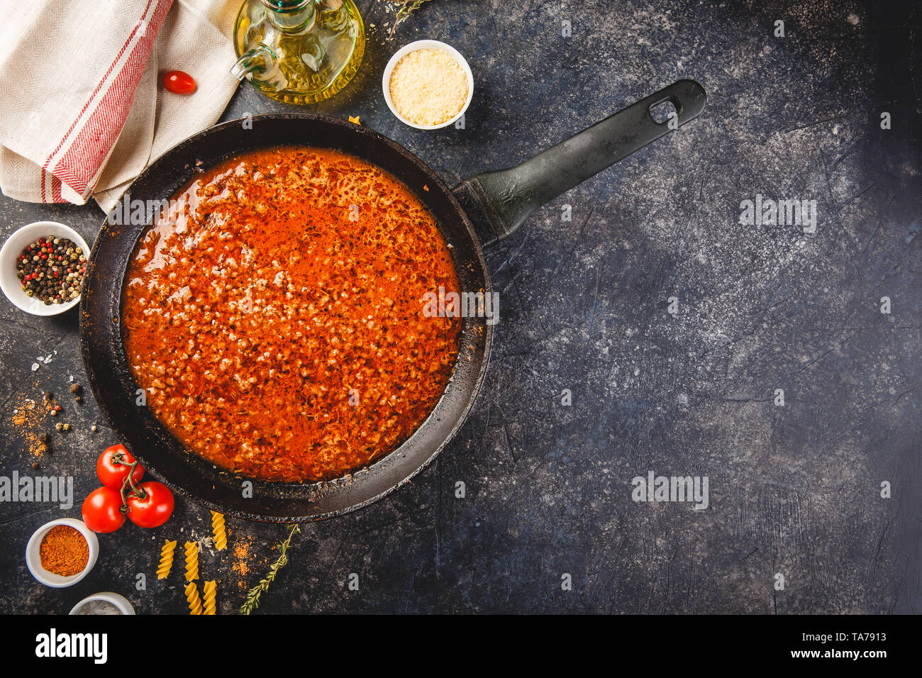 Classic italian bolognese sauce stewed in stewpot with ingredients on