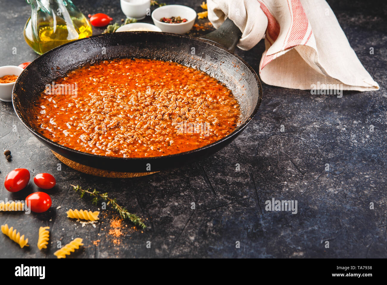 Classic italian bolognese sauce stewed in stewpot with ingredients on