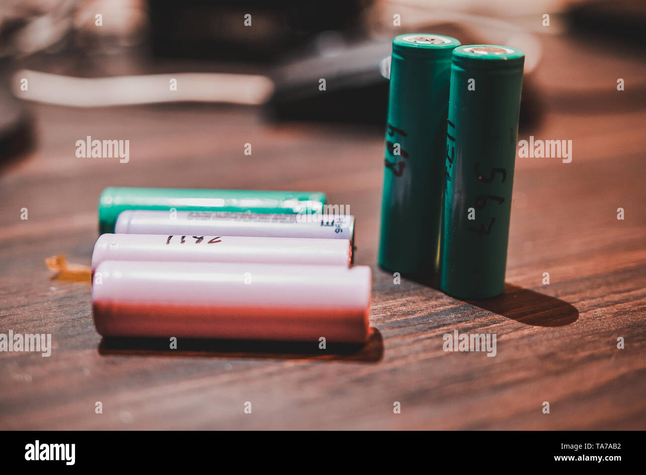 Colorful 18650 Lithium Ion Battery cell on a wooden table known for use  with vape or e cigarette. Also used to make laptop battery and power bank  Stock Photo - Alamy
