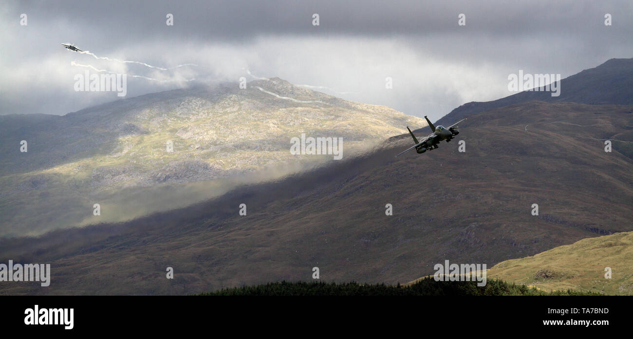 USAF F-15E Strike Eagle flying low level through the Mach Loop in Wales, UK Stock Photo