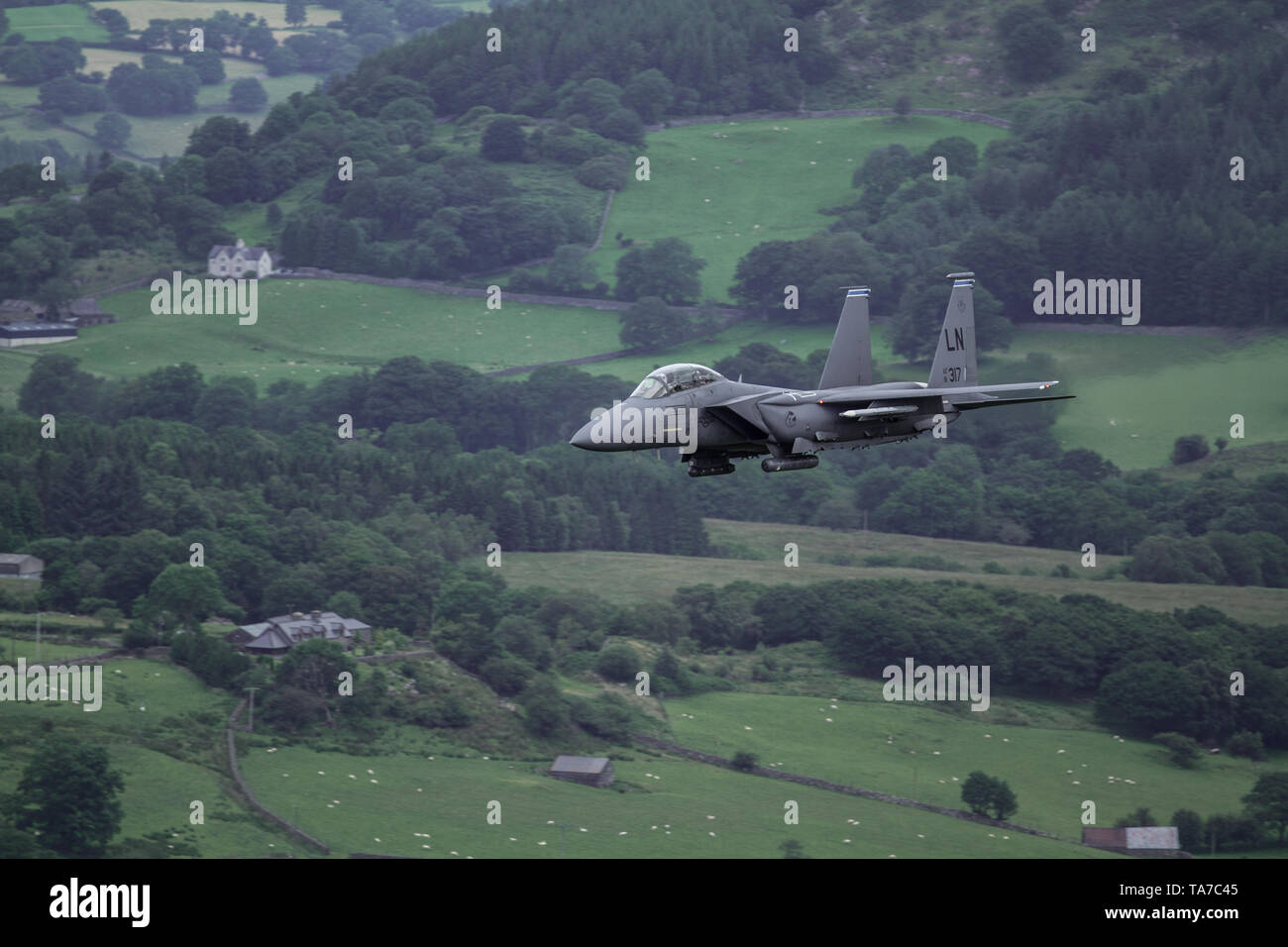 USAF F-15E Strike Eagle flying low level through the Mach Loop in Wales, UK Stock Photo