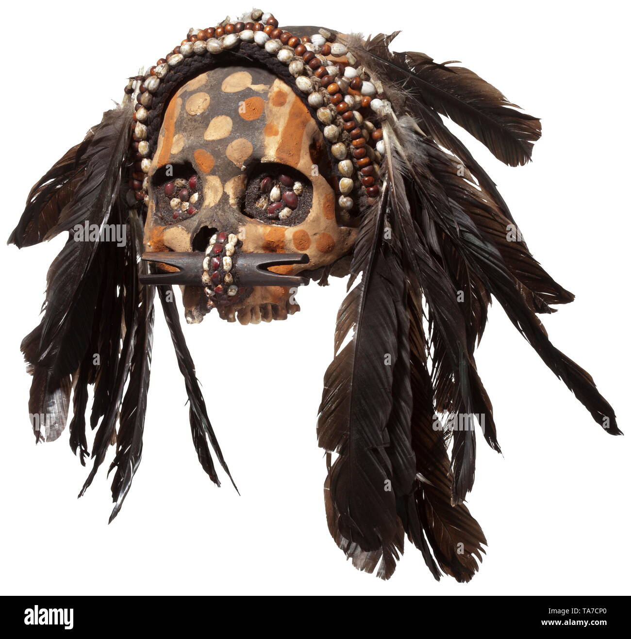 A Papua New Guinean ancestor's skull of the Asmat people Polychrome painted human skull without lower jaw, the eye sockets filled with seeds. Nose with elaborate nose plug. Textile headdress with shells and feathers. Height 15 cm. historic, historical, Indonesian archipelago, Indonesia, Far East, Asia, Asian, ethnology, ethnicity, ethnic, tribal, object, objects, stills, clipping, clippings, cut out, cut-out, cut-outs, Additional-Rights-Clearance-Info-Not-Available Stock Photo