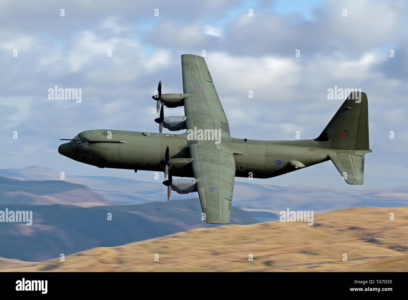 RAF Lockheed C-130 Hercules flying low level in the Mach Loop in Wales, UK Stock Photo