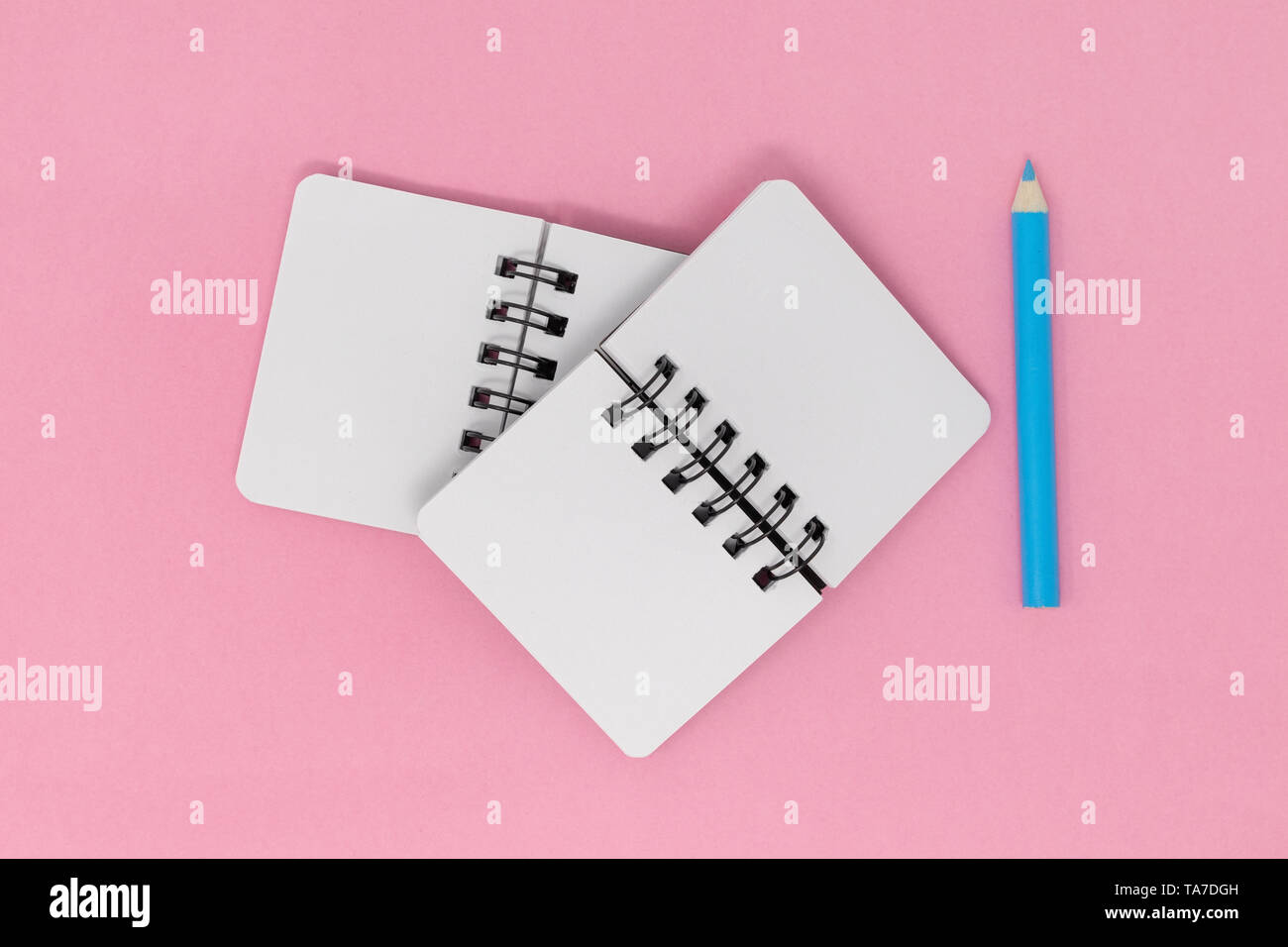 Open notebooks and pencil on a pink background Stock Photo - Alamy