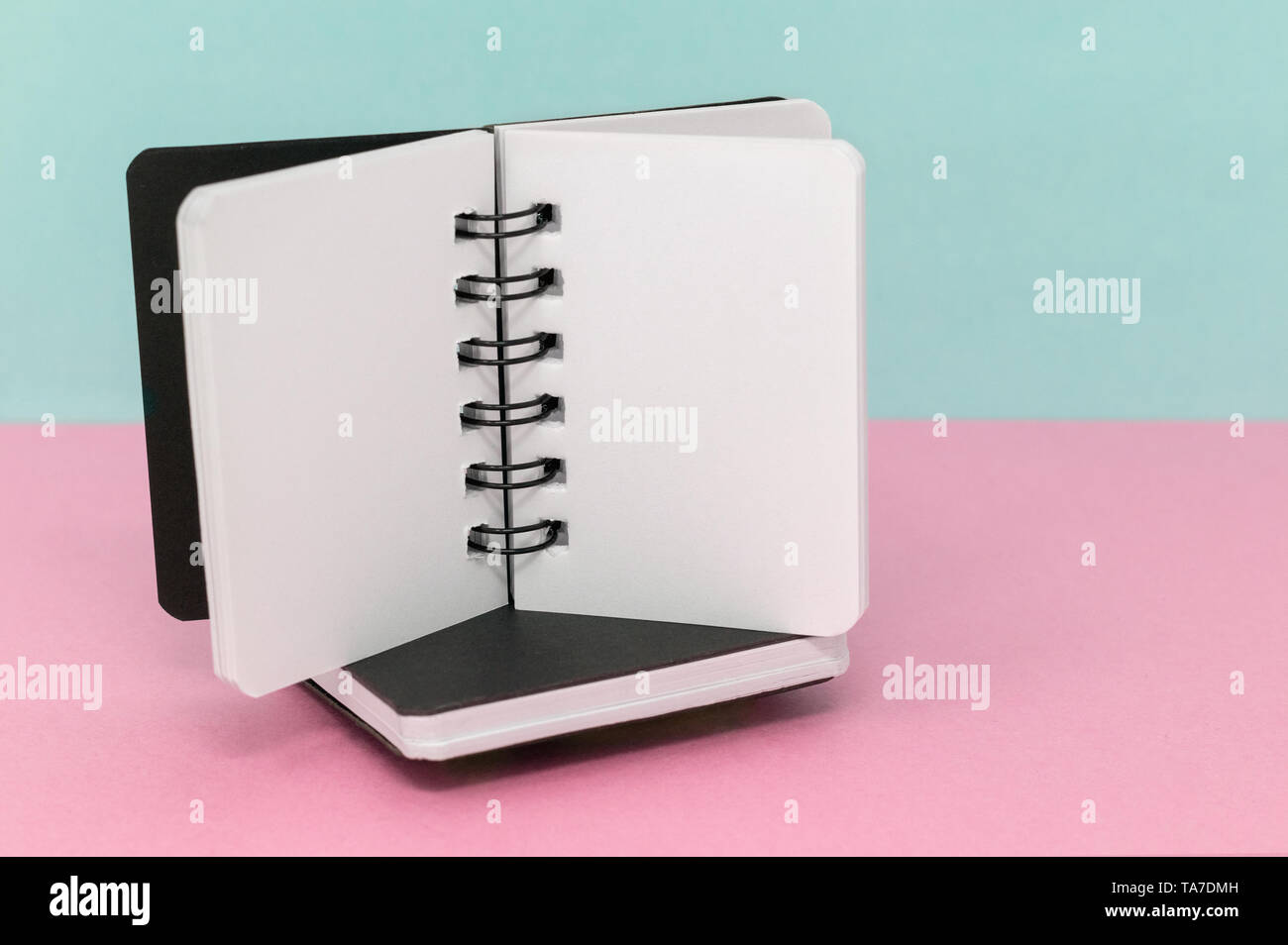 Two notebooks on a pink and blue green background, with space for text Stock Photo