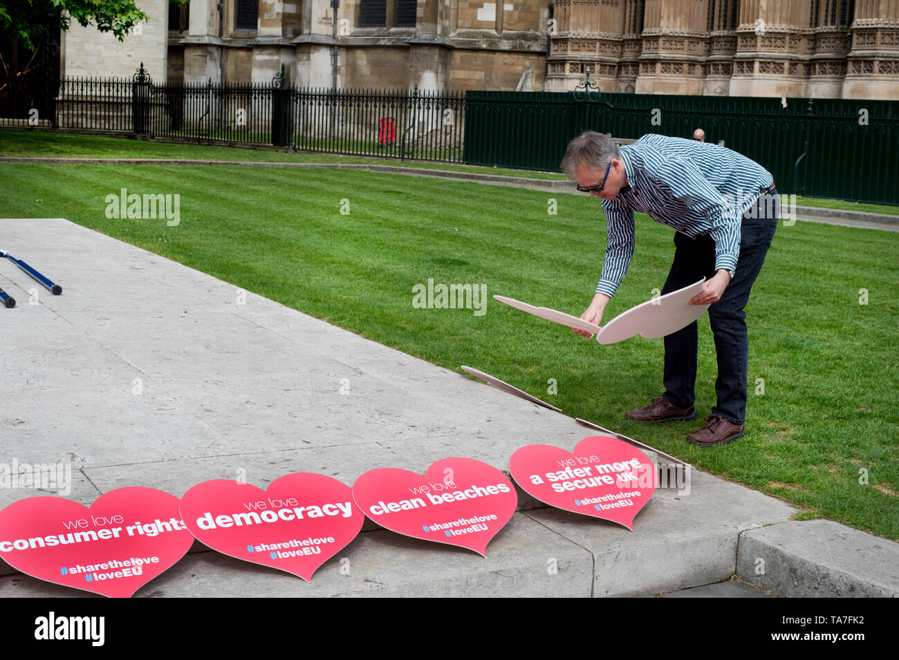 Westminster. Opposite Houses of Parliament May 22nd 2019. Protest to stop Brexit by Remainers. A man lays out a number of love hearts, each with a pos Stock Photo