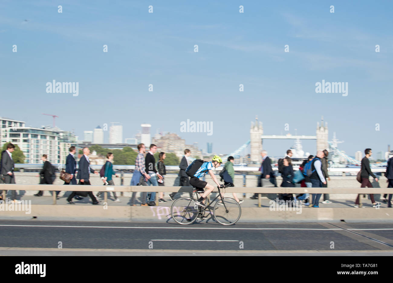 City cyclist (Motion Blur) crossing London Bridge with a view of tower bridge as background Stock Photo
