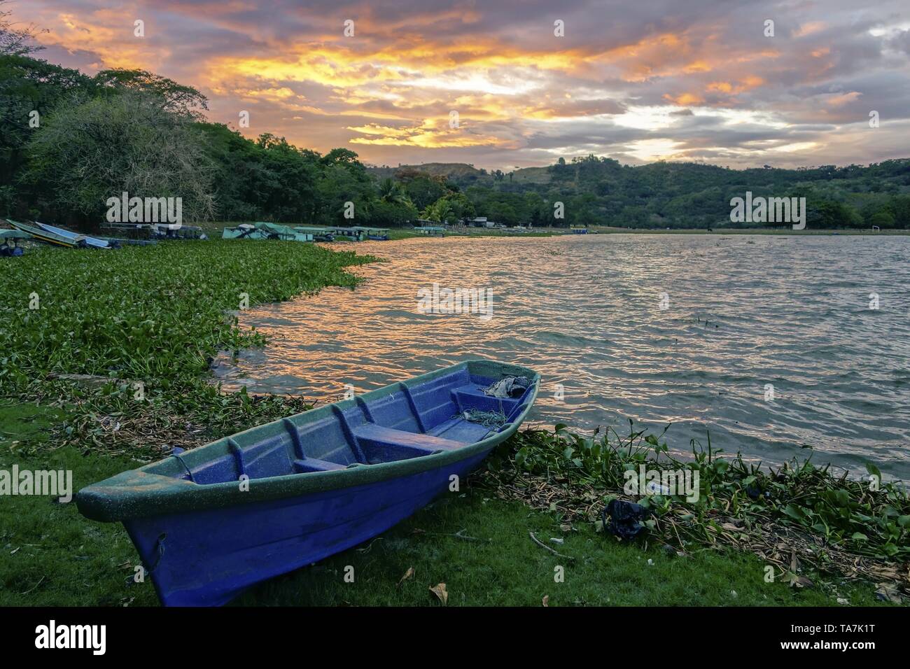 Blue Fishing Boat on Shore of Beautiful Lake Suchitlan and Dramatic Sunset Sky near Town of