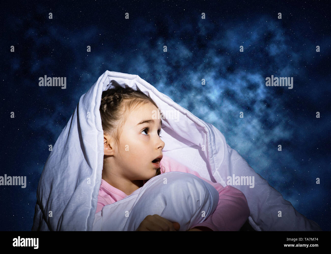 Surprised child hiding under blanket Stock Photo Alamy