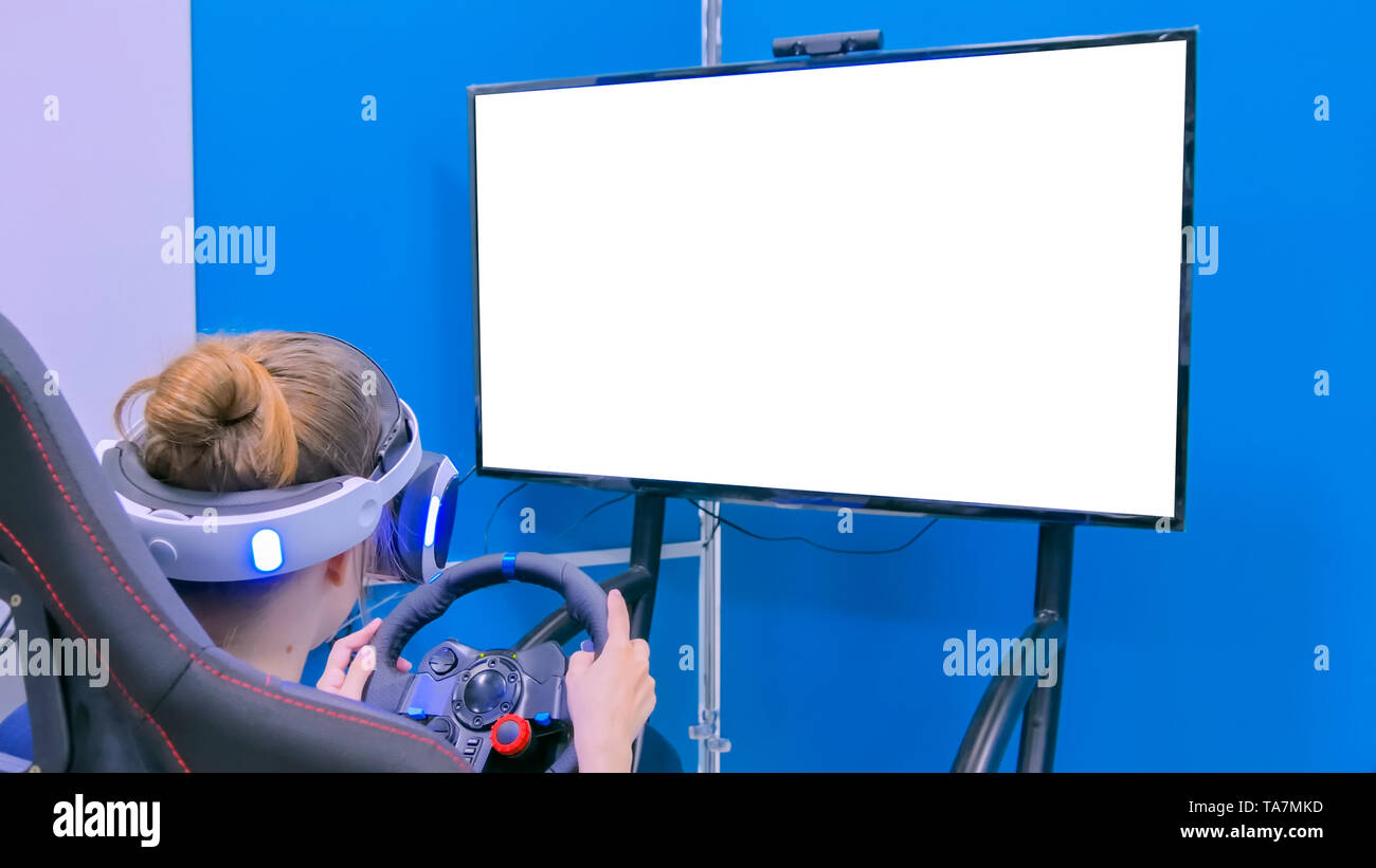 Young woman using virtual reality headset with special wheel joystick Stock Photo