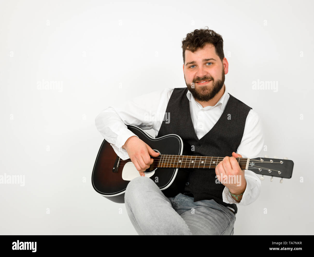 Man With Black Hair And Beard Playing And Singing With Acoustic
