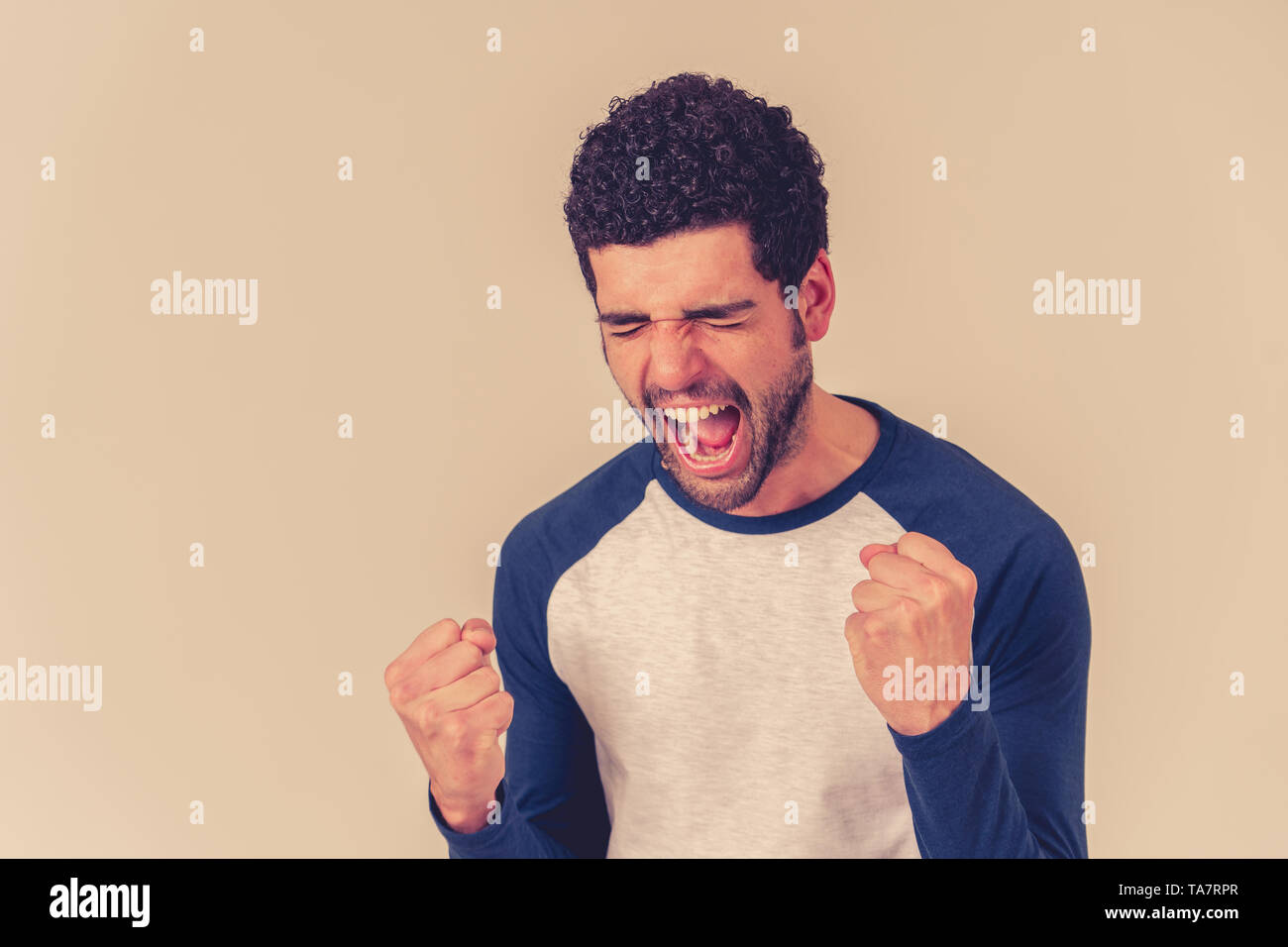 Portrait of young happy and excited man winning the lottery celebrating goal or having great success with proud face. In People success and Facial Exp Stock Photo