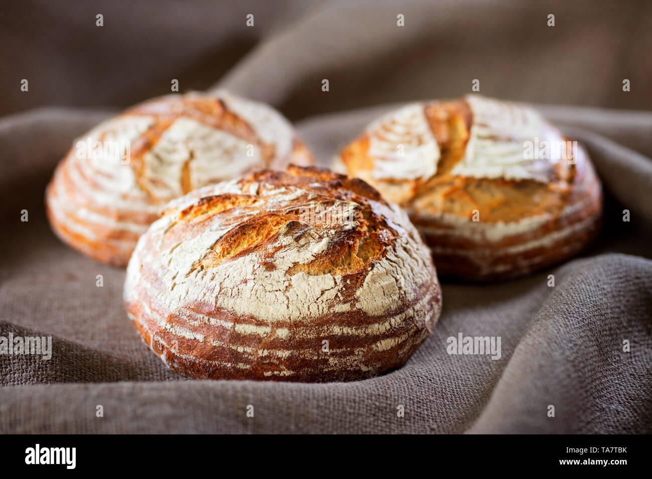 Three industrial round rye bread on burlap canvas Stock Photo