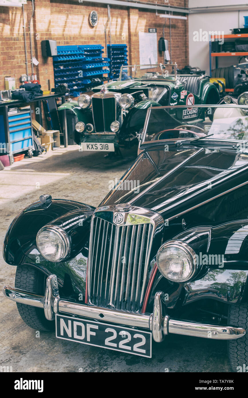 1954 MG midget  in a workshop at Bicester Heritage Centre ‘Drive it day’. Bicester, Oxfordshire, England. Vintage filter applied Stock Photo