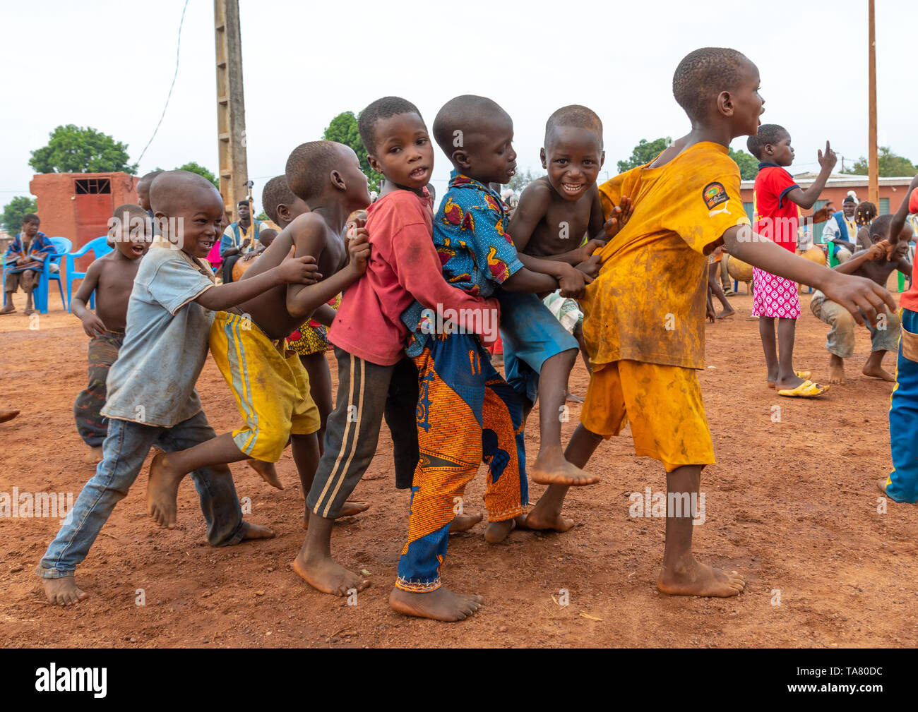 African children dancing in line during the Boloye dance of the panther man, Savanes district, Waraniene, Ivory Coast Stock Photo