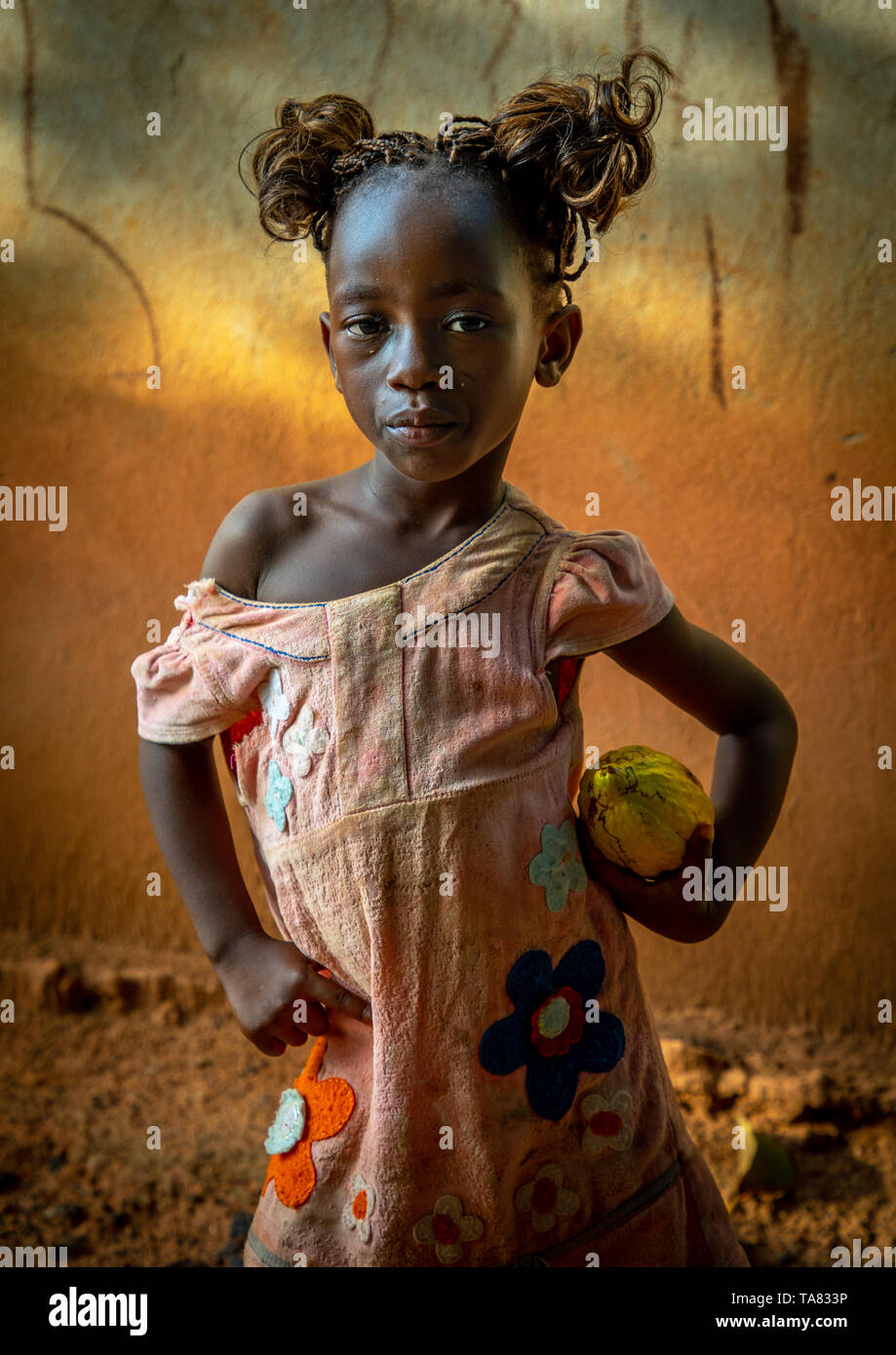 Cute african girl with a cocoa fruit pod in her hands, Savanes district, Yamoussoukro, Ivory Coast Stock Photo