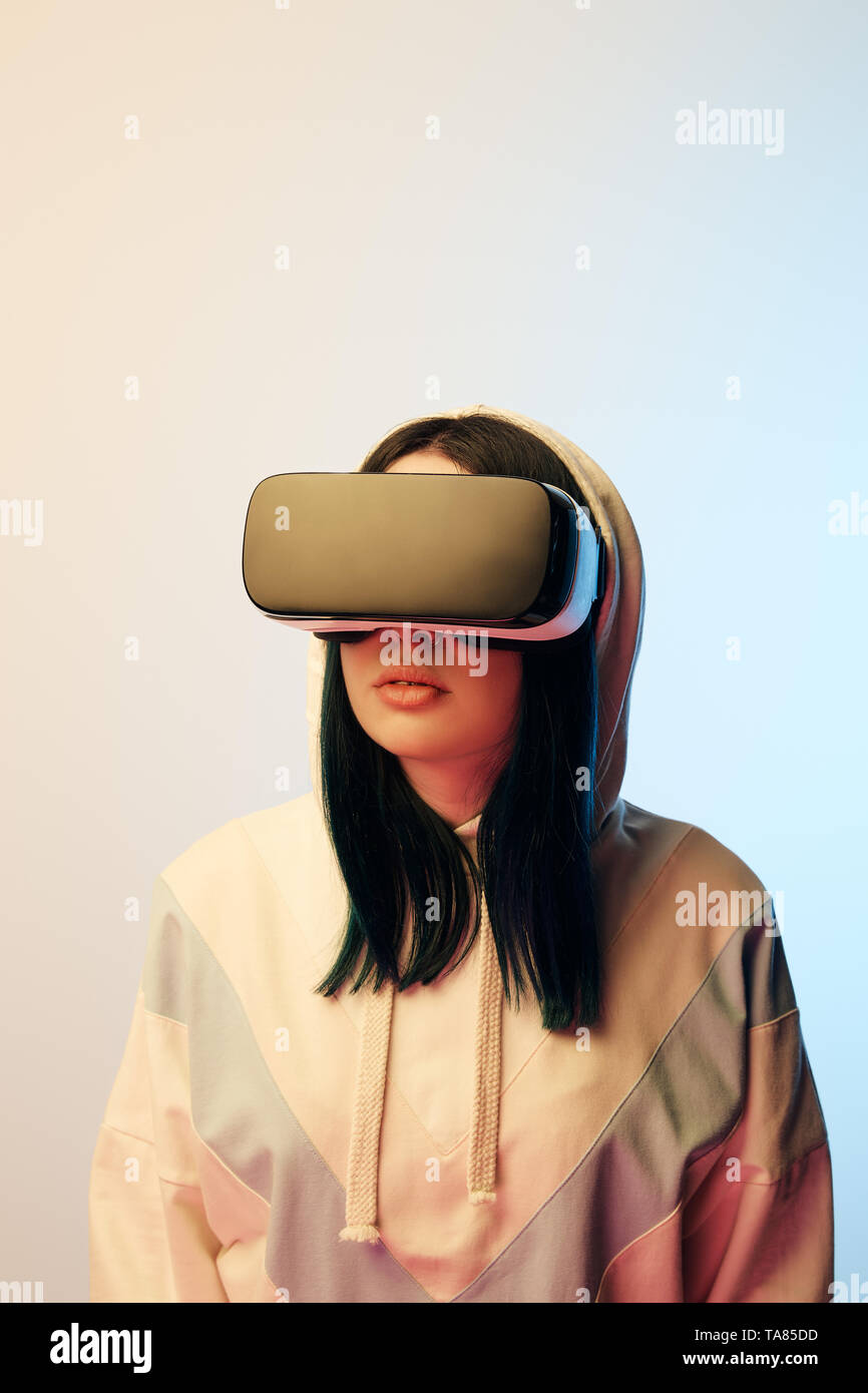 beautiful brunette woman in virtual reality headset on beige and blue ...