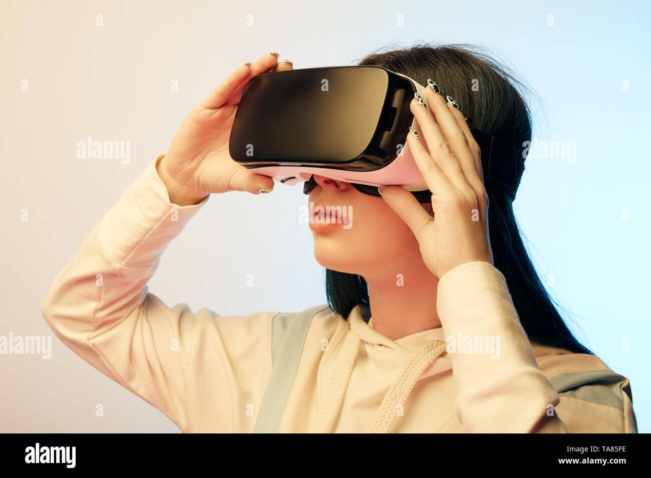 beautiful brunette woman touching virtual reality headset on beige and ...