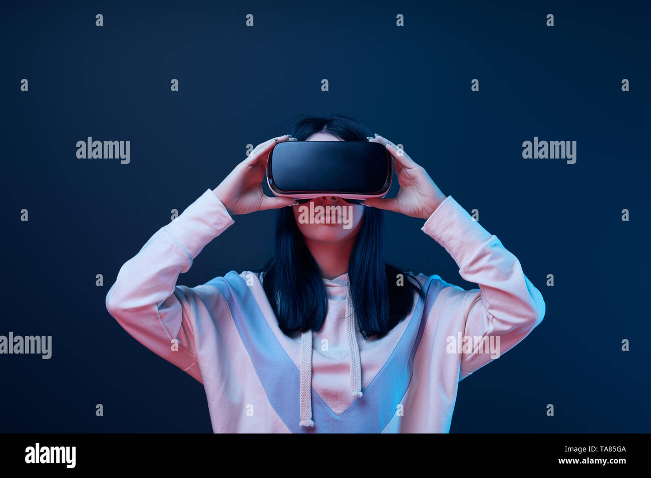 brunette young woman touching virtual reality headset on blue Stock ...