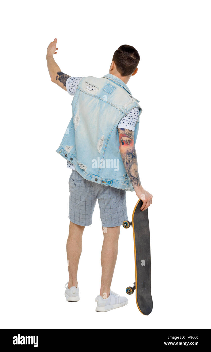 Back view of a pointing man with a skateboard. Rear view people collection.  backside view of person.  Isolated over white background. Guy leaning on  Stock Photo