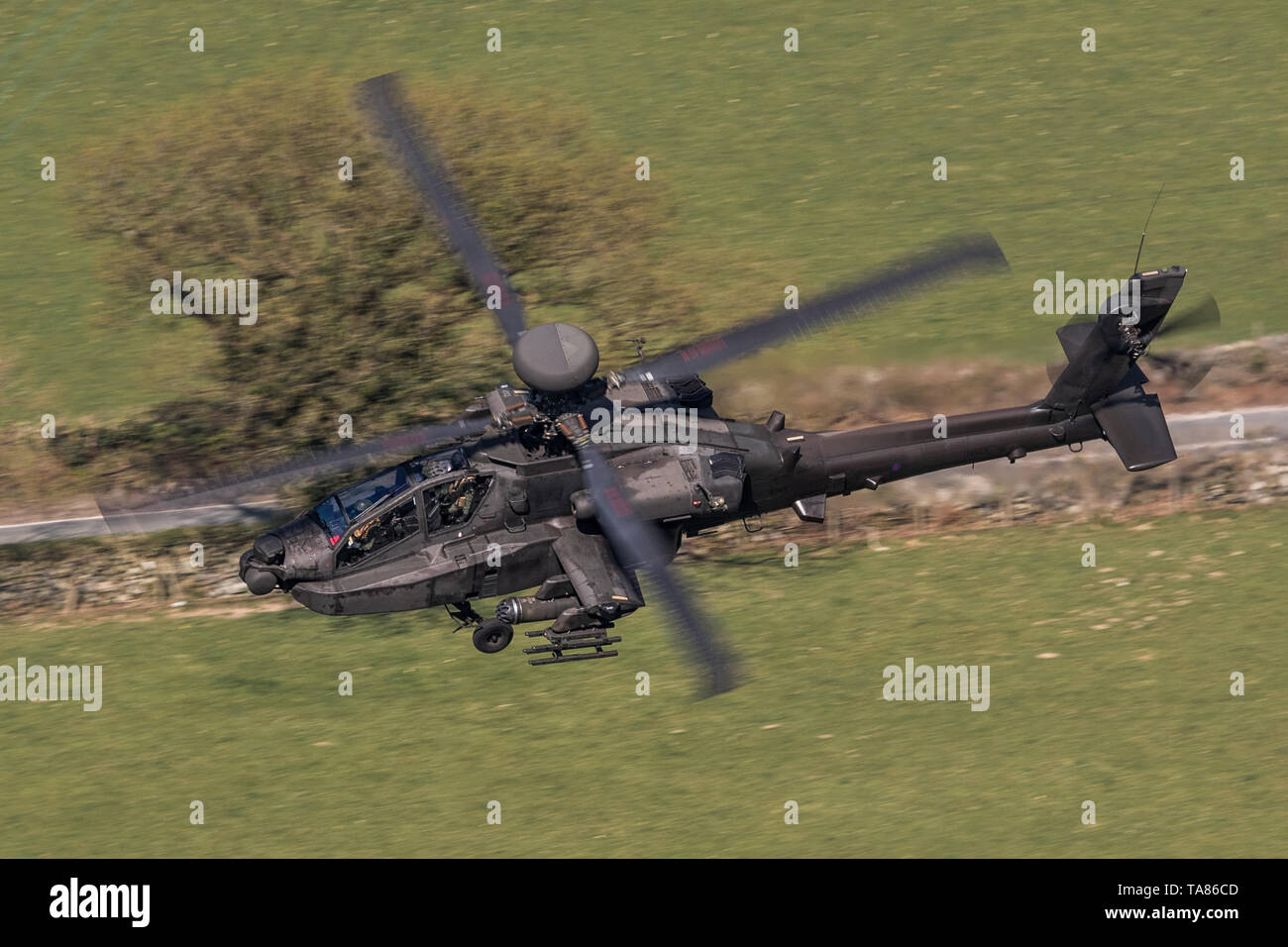 Army Air Corps WAH-64 Apache flying low level in the Mach Loop in Wales, UK Stock Photo