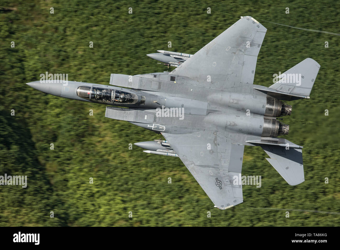 USAF F-15E Strike Eagle flying low level through the Mach Loop in Wales, UK Stock Photo