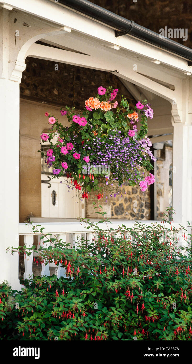 Charming hanging flower basket, cottage verandah, Devon, UK Stock Photo
