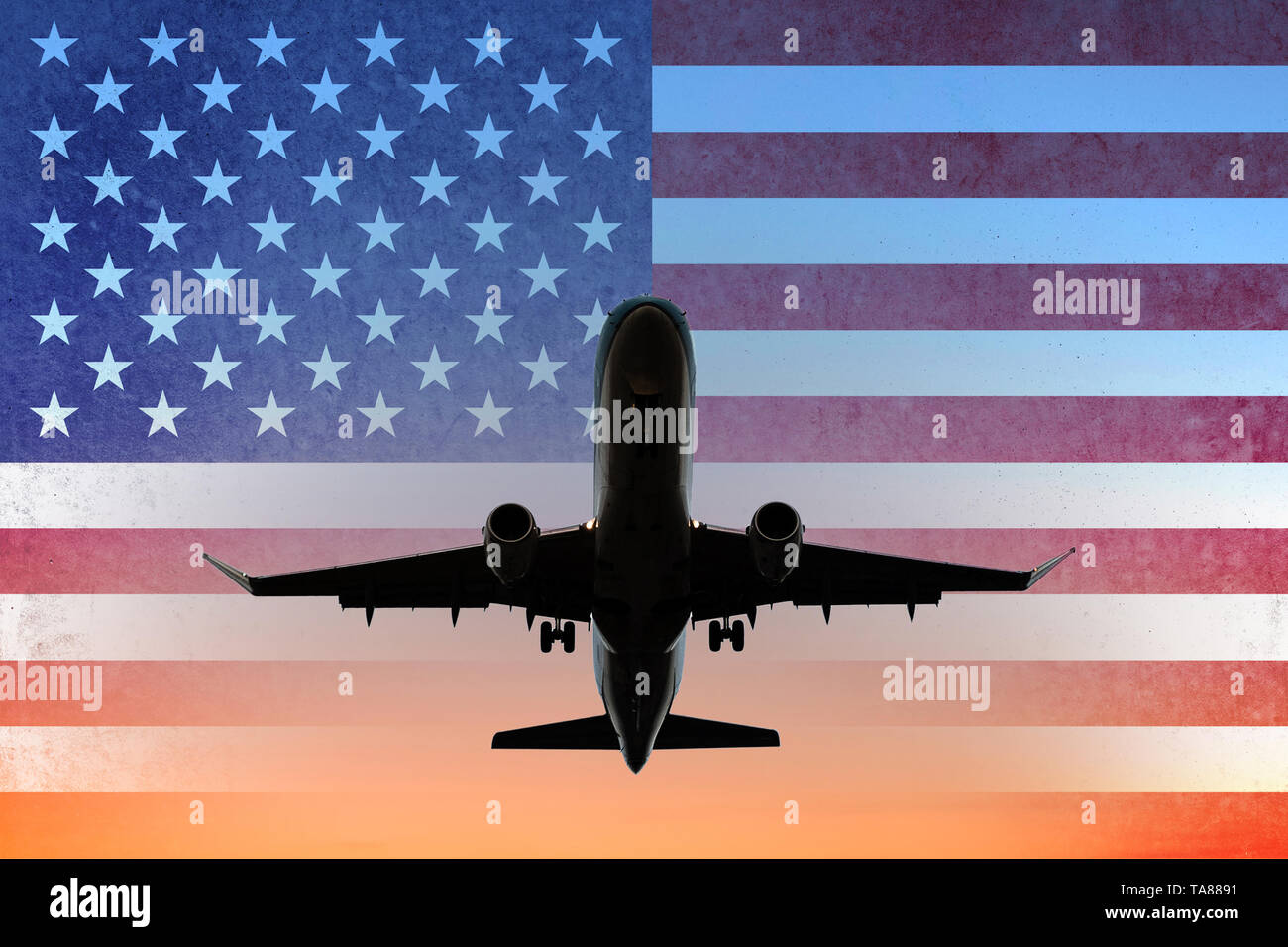 airplane on sunset sky with American flag - USA travel concept Stock Photo