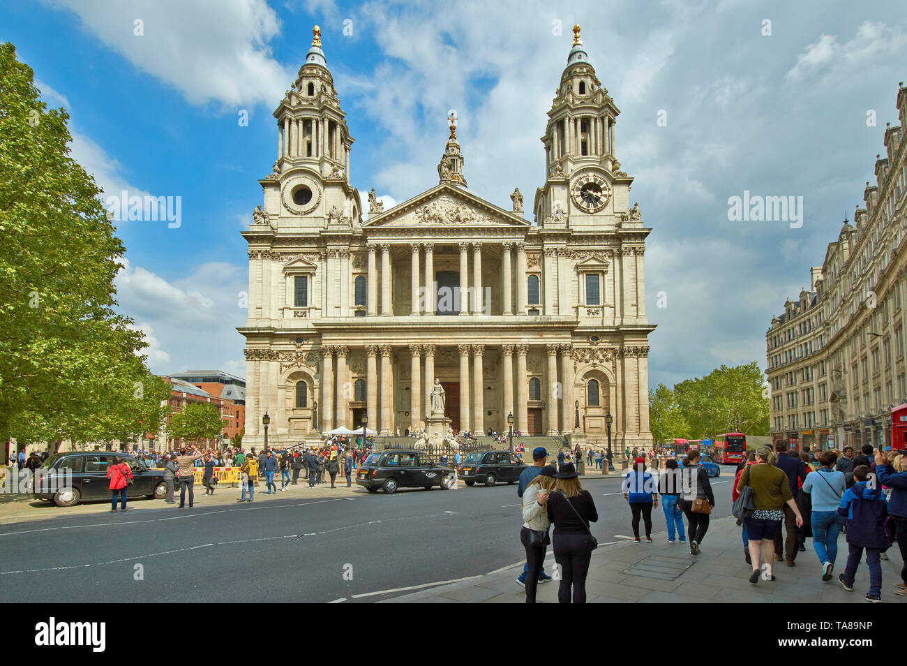 LONDON ST PAULS CATHEDRAL WITH PEOPLE ON THE PAVEMENTS AND WAITING TAXIS OR BLACK CABS Stock Photo